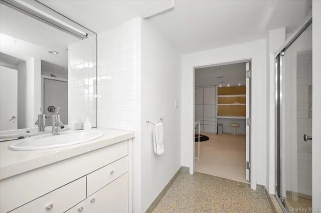 a bathroom with a shower sink and mirror