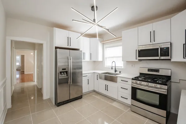 a kitchen with stainless steel appliances a stove a sink and a refrigerator