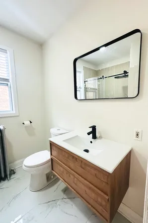 a bathroom with a sink mirror and toilet