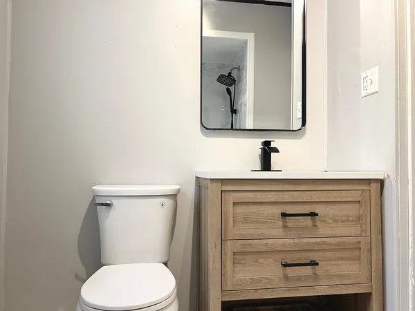a bathroom with a toilet sink and mirror