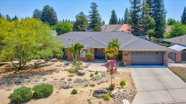 an aerial view of a house with garden space and a patio