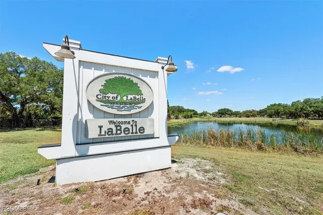 a view of a street with a big yard and large trees
