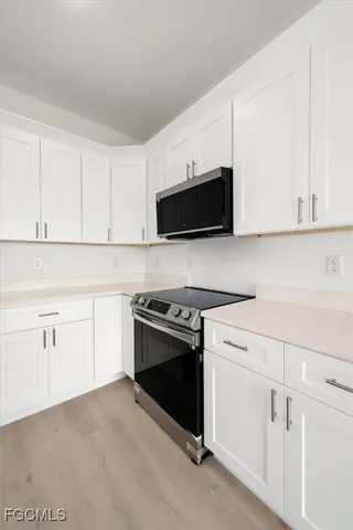 a kitchen with white cabinets and stainless steel appliances