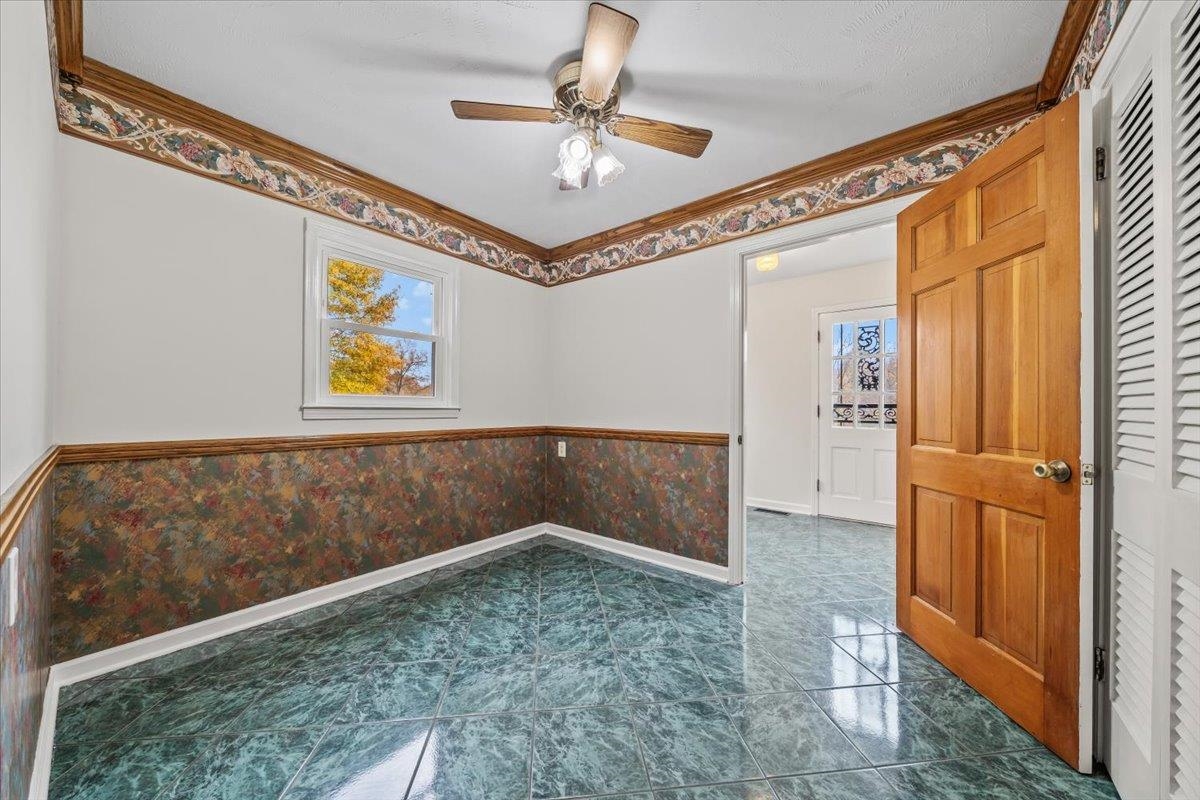 102 Linden Street Grand Junction, TN 38039 - Photo 14 of 37 Unfurnished room with a wainscoted wall, ornamental molding, ceiling fan, and wallpapered walls