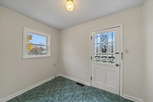 an empty room with a window and a ceiling fan