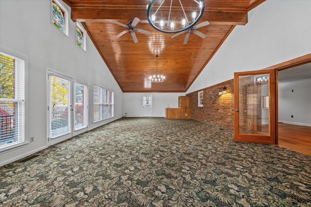 102 Linden Street Grand Junction, TN 38039 - Photo 17 of 37 Unfurnished living room with high vaulted ceiling, a wood ceiling with exposed beams, carpet floors, and a chandelier