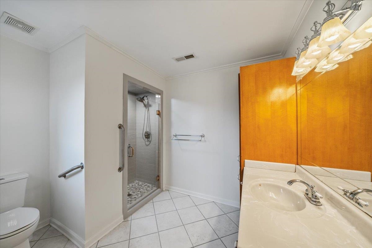 102 Linden Street Grand Junction, TN 38039 - Photo 23 of 37 Bathroom featuring crown molding, light tile patterned floors, vanity, and a shower stall
