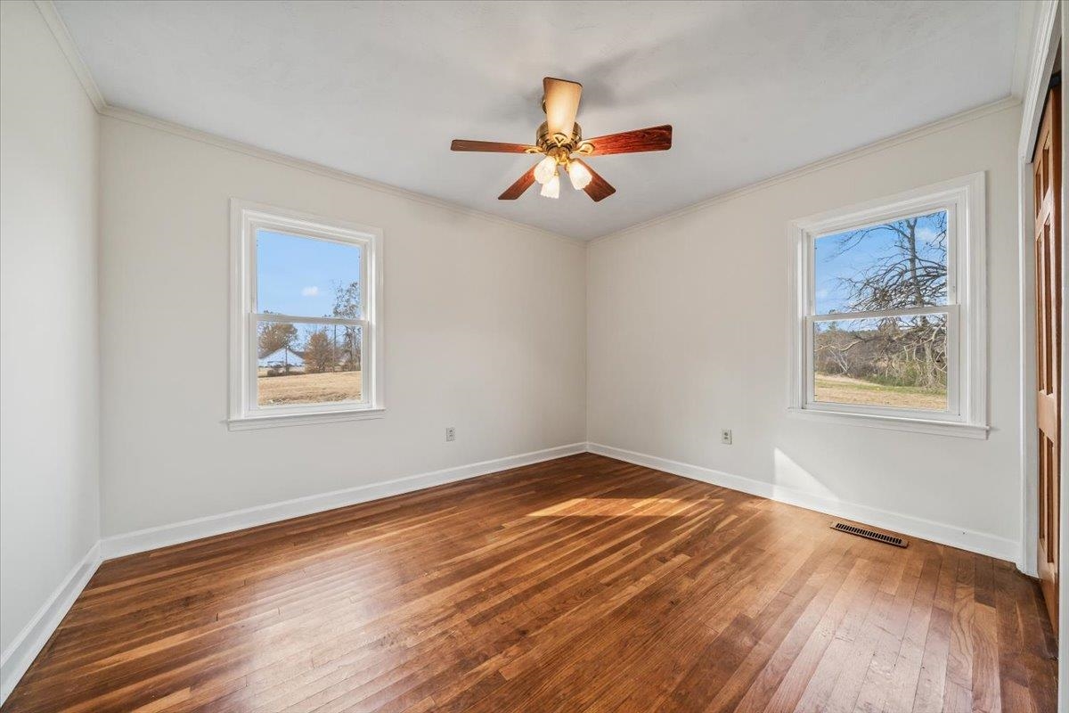 102 Linden Street Grand Junction, TN 38039 - Photo 25 of 37 Spare room featuring ornamental molding, dark wood-type flooring, and a ceiling fan