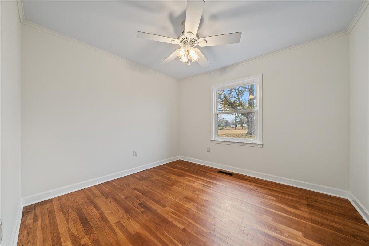 102 Linden Street Grand Junction, TN 38039 - Photo 26 of 37 Spare room with crown molding, wood finished floors, and a ceiling fan
