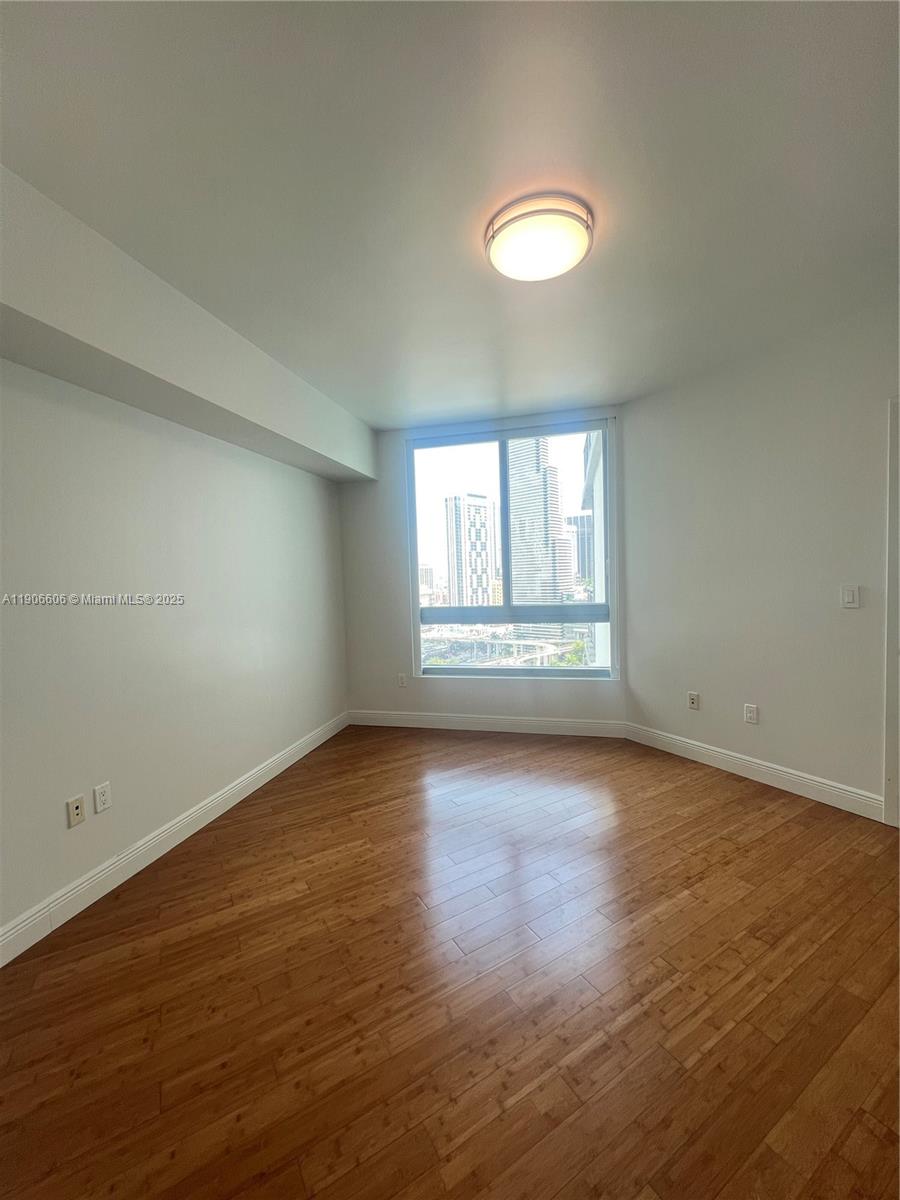 350 South Miami Avenue, Unit 1905 Miami, FL 33130 - Photo 12 of 27 an empty room with wooden floor and windows