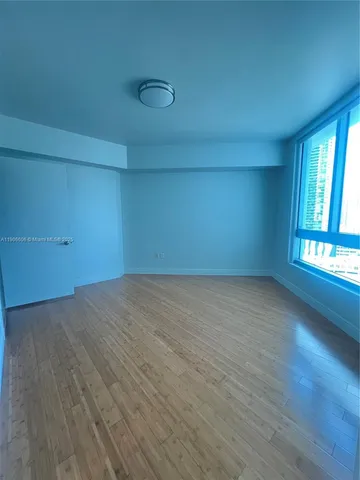 a room with walk in closet and wooden floor