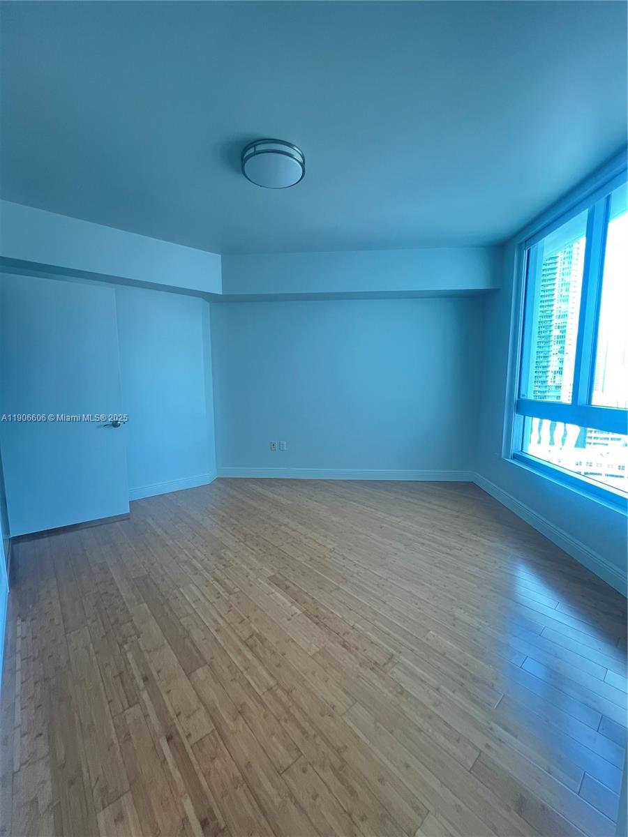 350 South Miami Avenue, Unit 1905 Miami, FL 33130 - Photo 7 of 27 an empty room with wooden floor and windows