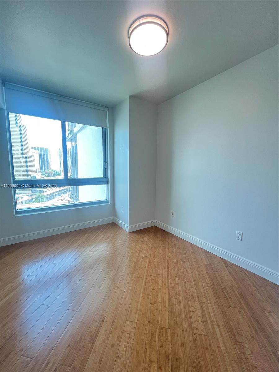 350 South Miami Avenue, Unit 1905 Miami, FL 33130 - Photo 10 of 27 an empty room with wooden floor and windows