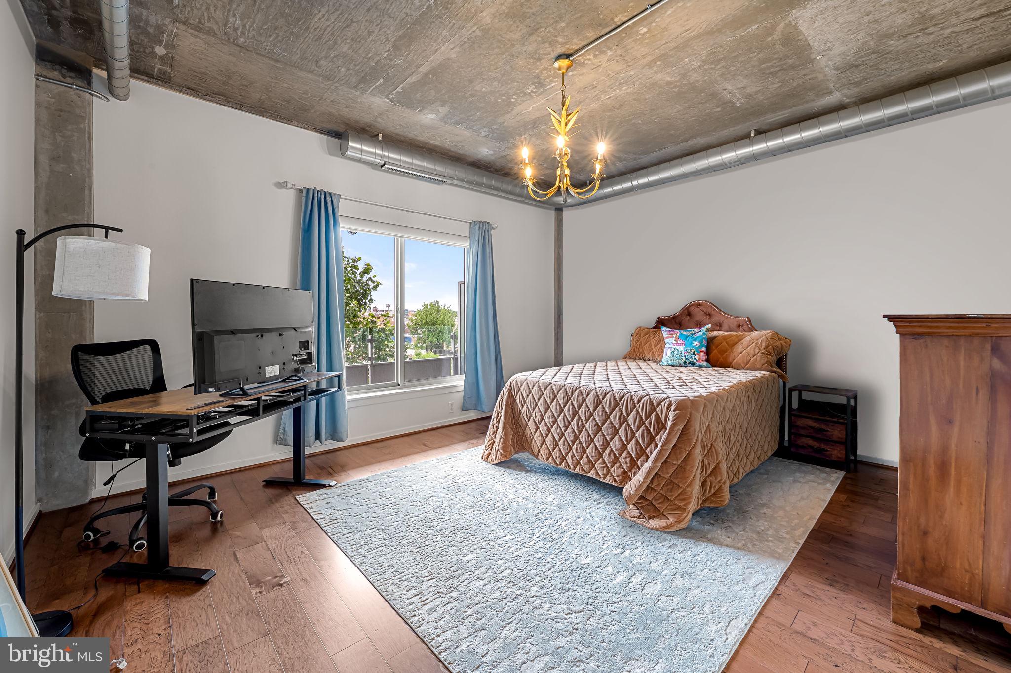 1200 Steuart Street, Unit 425 Baltimore, MD 21230 - Photo 12 of 33 a bedroom with a bed and a chandelier
