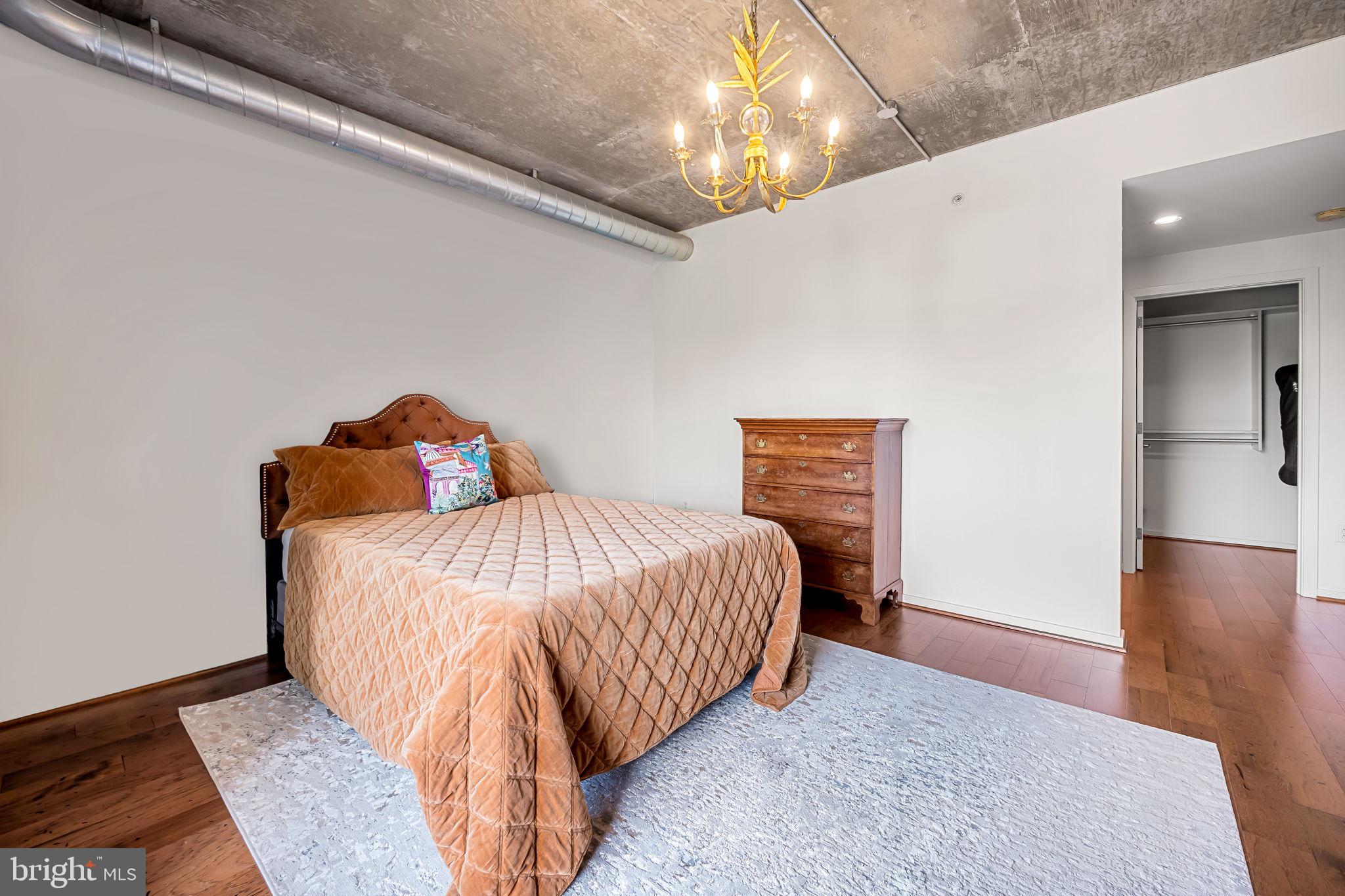 1200 Steuart Street, Unit 425 Baltimore, MD 21230 - Photo 13 of 33 a bedroom with a bed and wooden floor