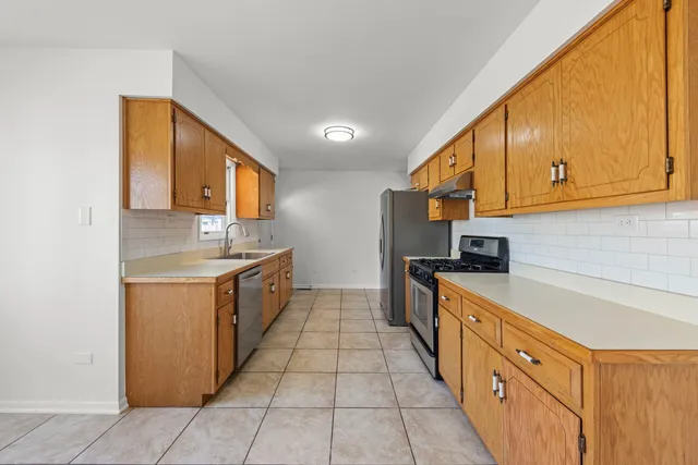 a large kitchen with stainless steel appliances granite countertop a sink and cabinets