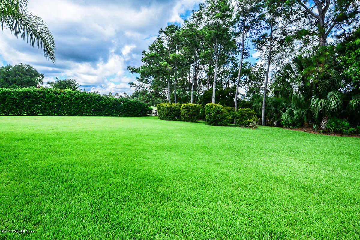 302 Pablo Road Ponte Vedra Beach, FL 32082 - Photo 20 of 28 a view of a grassy field with trees in the background