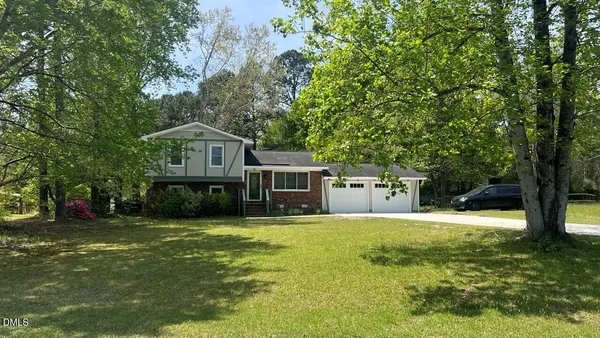 a view of a house with a yard and sitting area