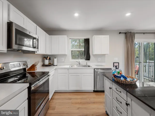 a kitchen with a sink stove top oven and microwave