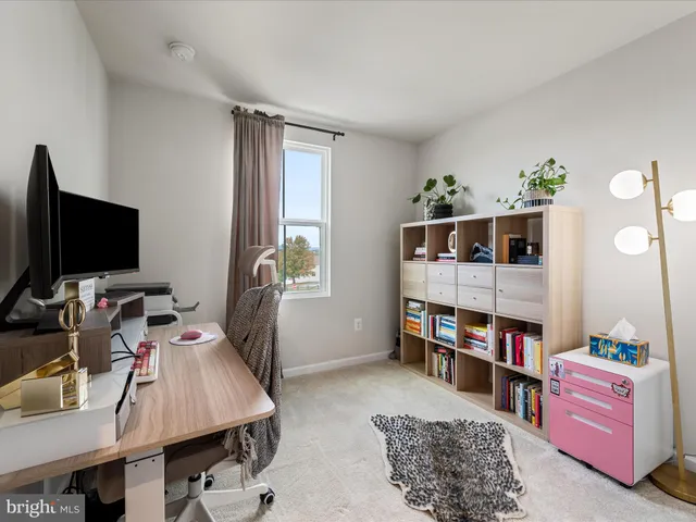 a view of a livingroom with workspace and a window