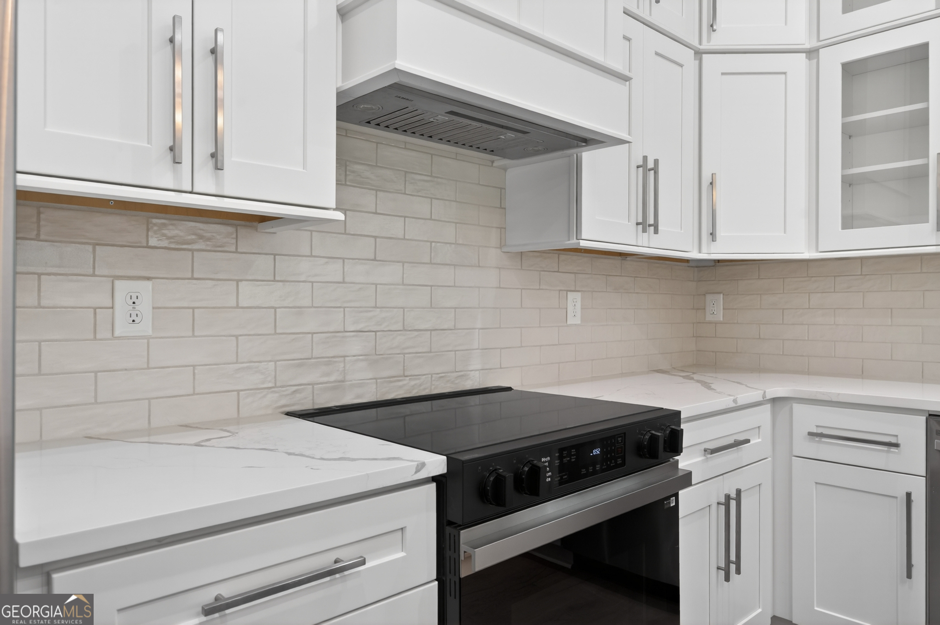 1455 Laney Drive Locust Grove, GA 30248 - Photo 11 of 37 a kitchen with a stove and white cabinets