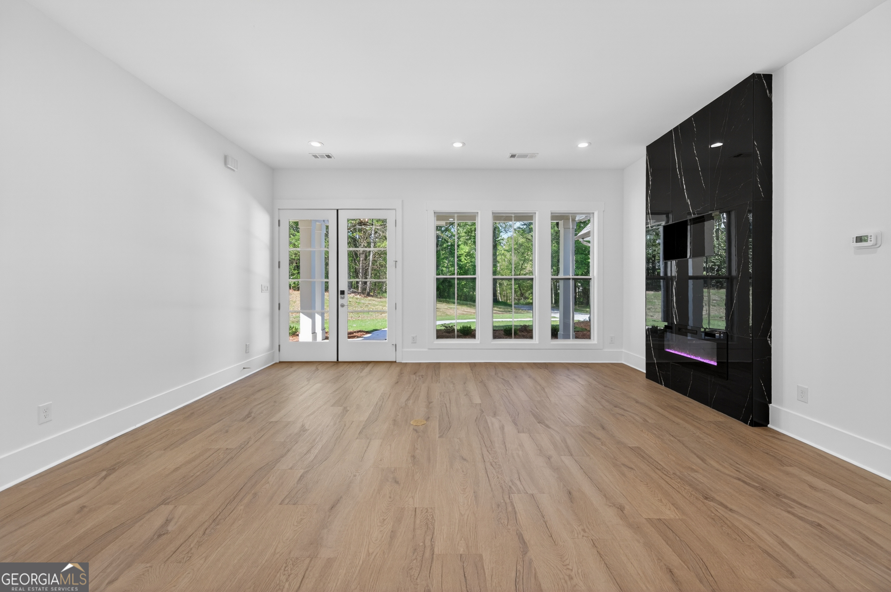 1455 Laney Drive Locust Grove, GA 30248 - Photo 6 of 37 a view of an empty room with wooden floor and a window