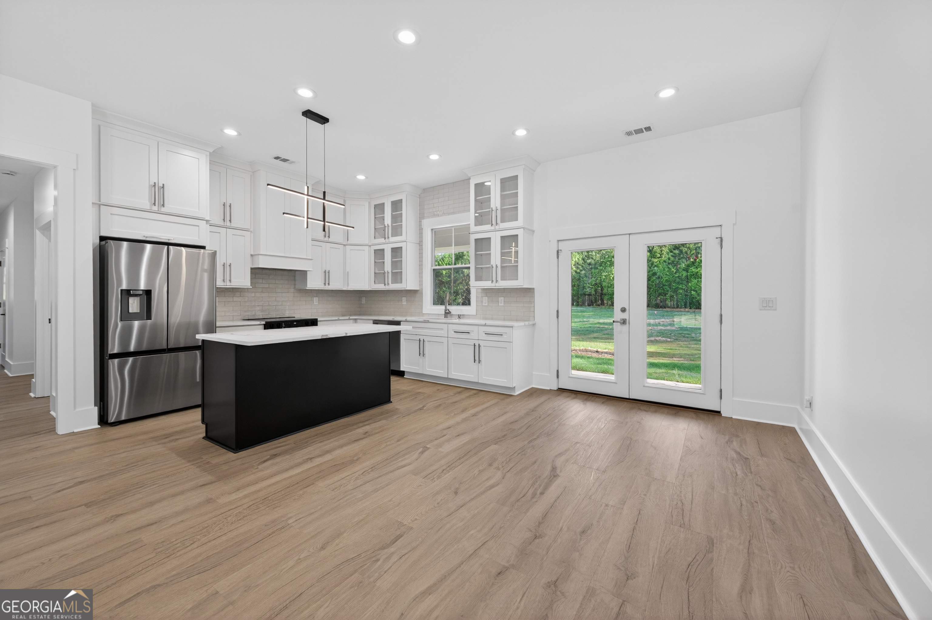 1455 Laney Drive Locust Grove, GA 30248 - Photo 7 of 37 a kitchen with stainless steel appliances kitchen island wooden cabinets and wooden floors