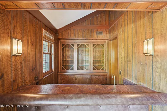a view of a backyard with table and chairs plants and large trees