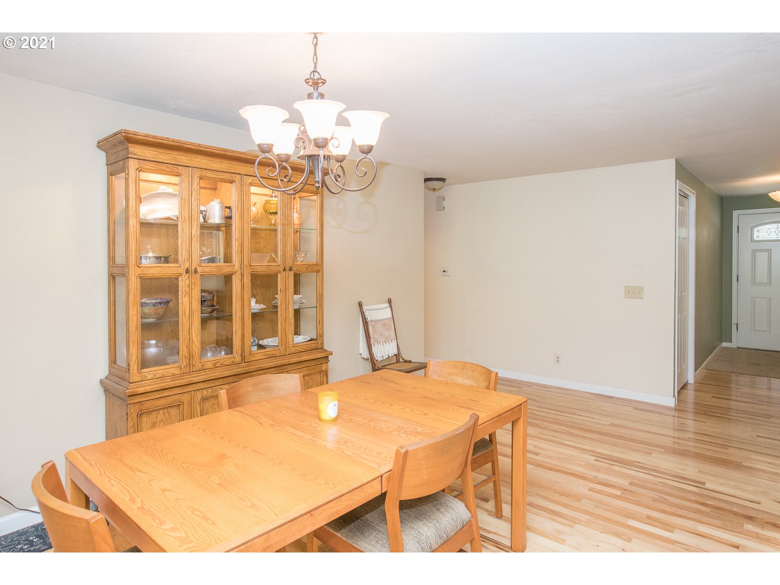 90361 Baker Road Elmira, OR 97437 - Photo 8 of 26 a dining room with wooden floor a chandelier a wooden table and chairs