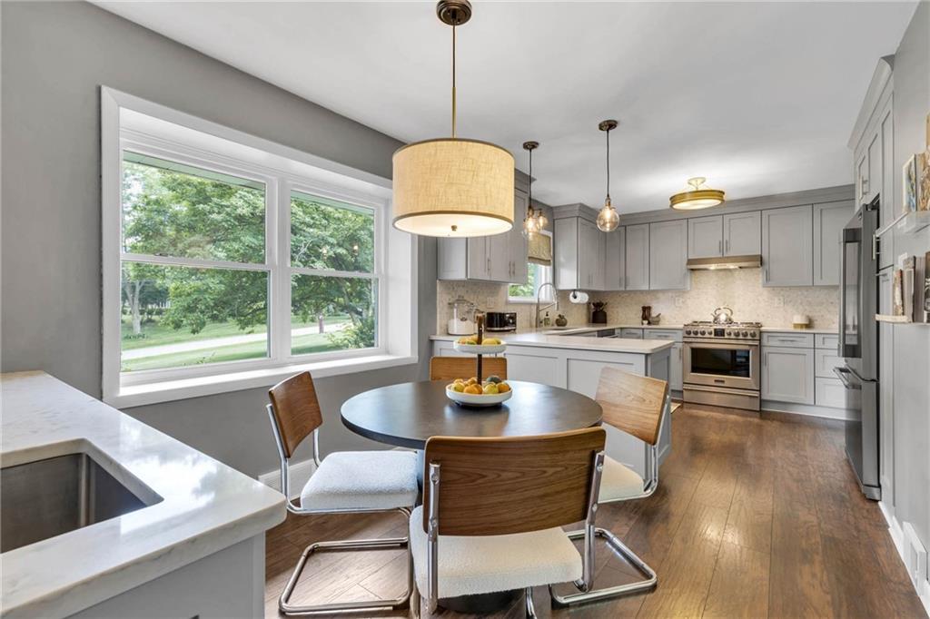 139 Laurel Drive Beaver, PA 15009 - Photo 14 of 46 a kitchen with stainless steel appliances granite countertop a stove a refrigerator a kitchen island a dining table and chairs with wooden floor