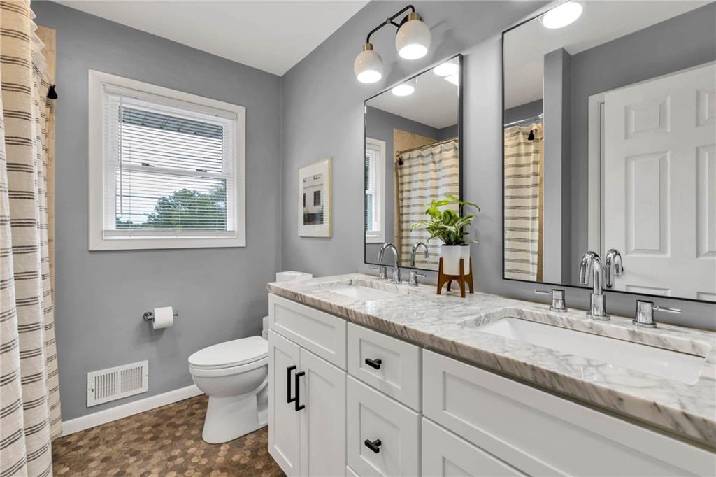 139 Laurel Drive Beaver, PA 15009 - Photo 35 of 46 a bathroom with a granite countertop sink toilet a large mirror and a window