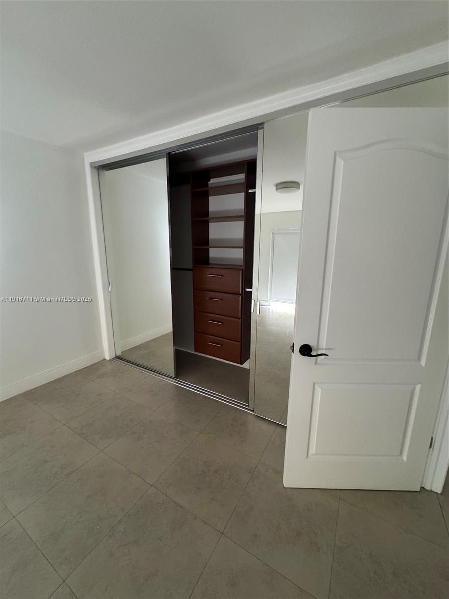5839 Southwest 74th Terrace, Unit 104 South Miami, FL 33143 - Photo 11 of 25 an empty room with closet and refrigerator