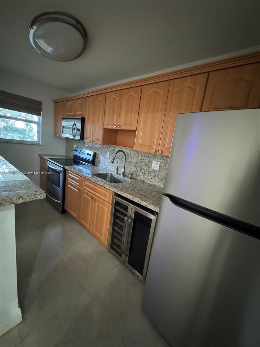 5839 Southwest 74th Terrace, Unit 104 South Miami, FL 33143 - Photo 2 of 25 a kitchen with stainless steel appliances granite countertop a sink stove and cabinets