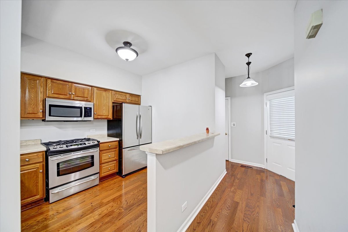 351 Fallbrook Court Schaumburg, IL 60107 - Photo 23 of 29 a kitchen with stainless steel appliances a stove refrigerator and a microwave