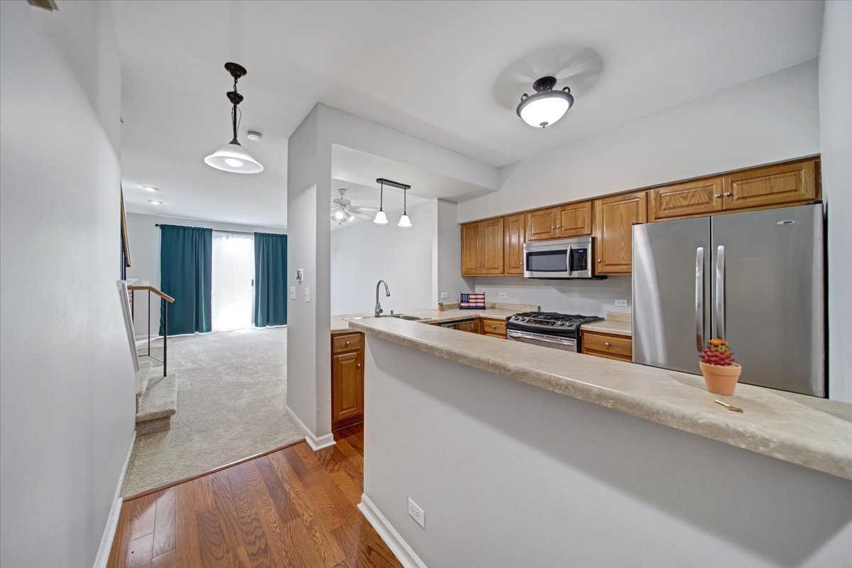 351 Fallbrook Court Schaumburg, IL 60107 - Photo 6 of 29 a view of a kitchen with stainless steel appliances a refrigerator and a flat screen tv