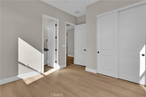 an empty room with wooden floor and white walls