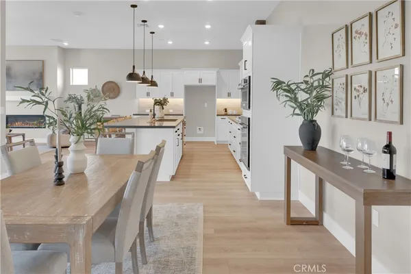 a kitchen with stainless steel appliances kitchen island granite countertop a table chairs and a refrigerator