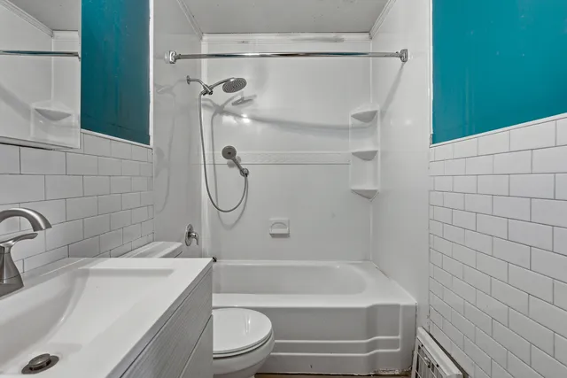 a bathroom with a shower a toilet and sink