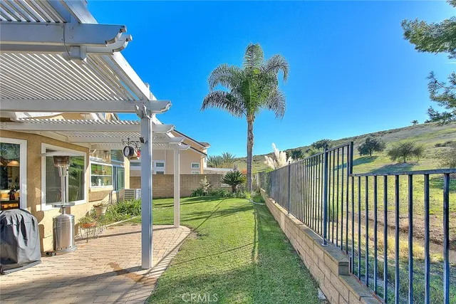 a patio with table and chairs and potted plants