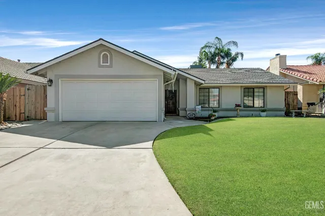 a front view of a house with a yard and trees