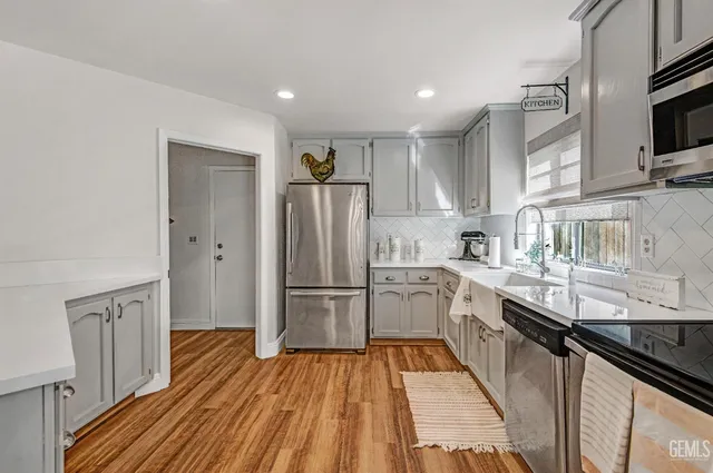 a kitchen with granite countertop a refrigerator stove and sink
