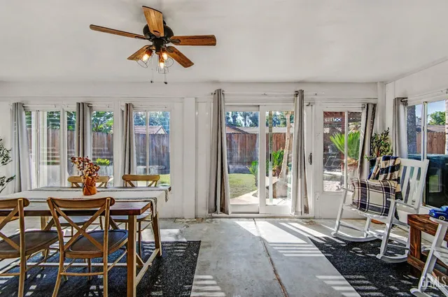 a living room with furniture a flat screen tv and a floor to ceiling window