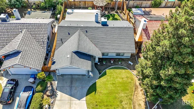 a aerial view of a house with swimming pool and large trees
