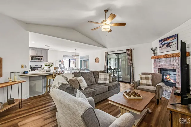 a living room with furniture kitchen view and a window