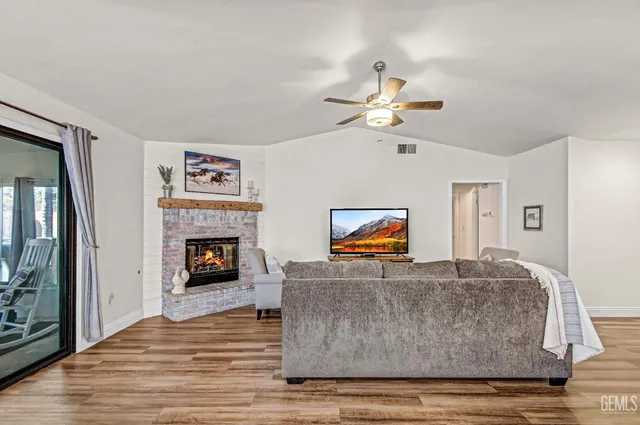 a living room with furniture a fireplace and a flat screen tv