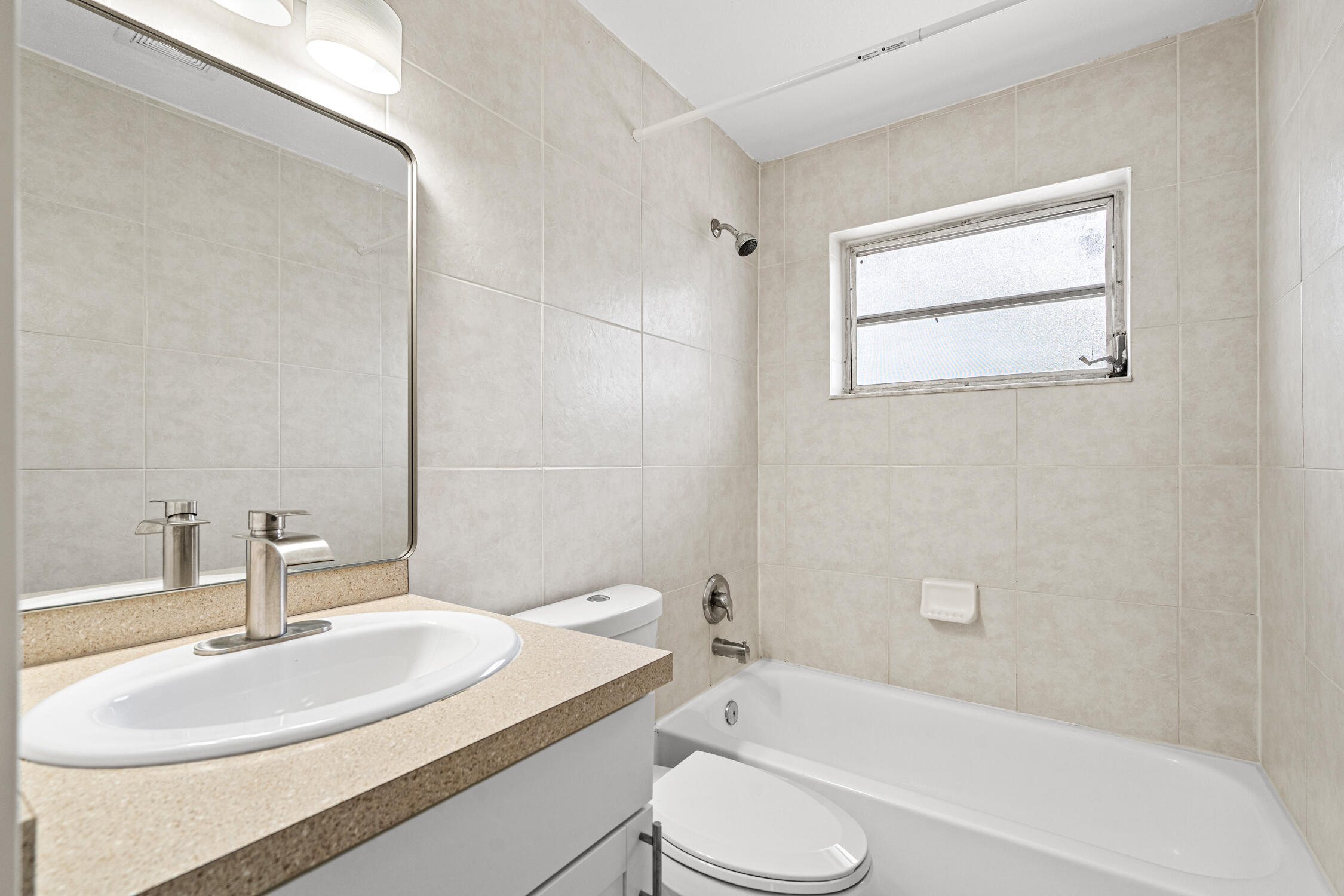 1908 Northwest 4th Avenue, Unit 207 Boca Raton, FL 33432 - Photo 3 of 10 a bathroom with a granite countertop sink toilet mirror and bathtub