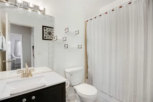 a bathroom with a sink a toilet and shower curtain