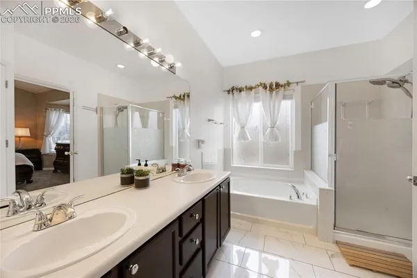 a bathroom with a double vanity sink a mirror a bathtub and shower