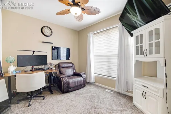 a view of a workspace with furniture and a window