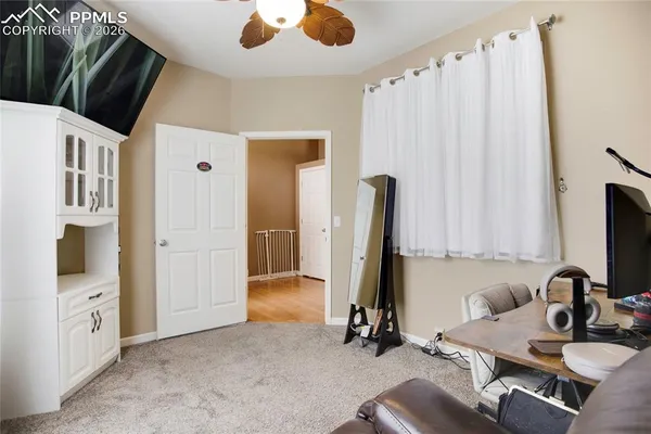 a view of a workspace with furniture and a large window